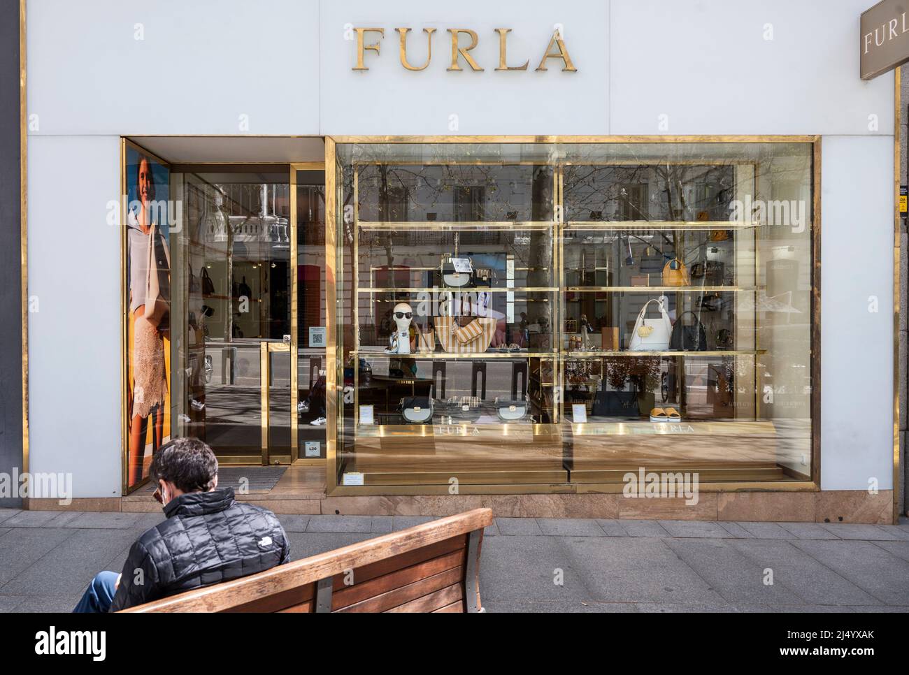 Madrid, Spain. 3rd Apr, 2022. A man sits on a bench in front of the Italian clothing luxury brand Furla store in Spain. (Credit Image: © Xavi Lopez/SOPA Images via ZUMA Press Wire) Stock Photo