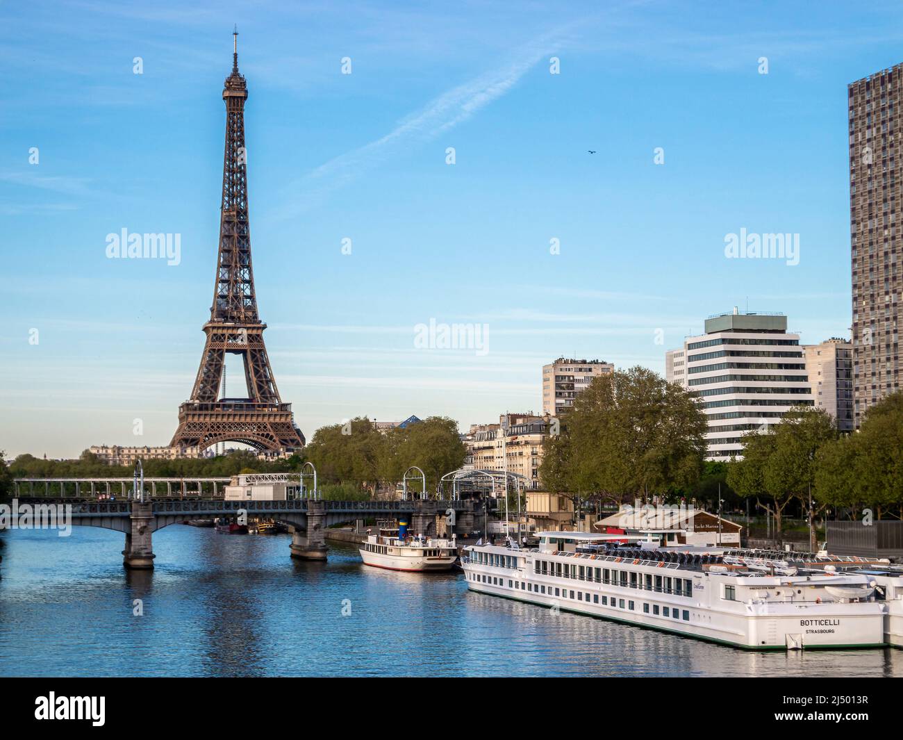 Daytime view of the Eiffel Tower along with bridges and boats on the