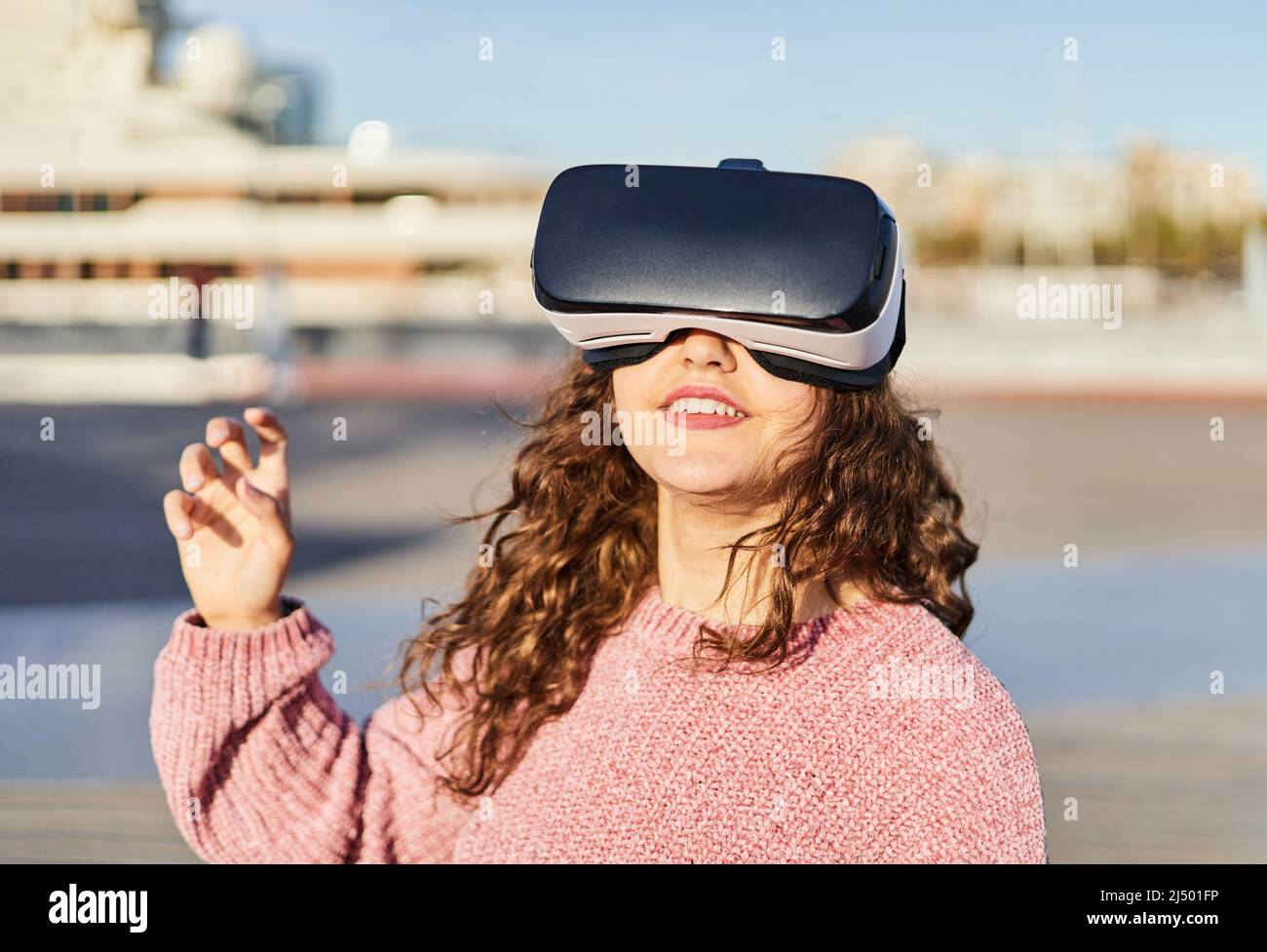 Young girl with VR goggles ready to enter the virtual world. Concept of metaverse Stock Photo