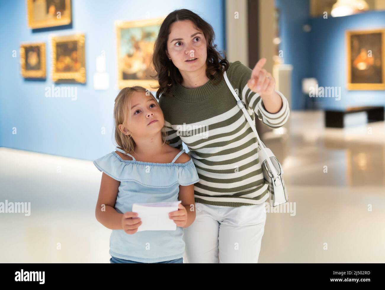 Woman with girl looking at modern painting in museum of art Stock Photo ...