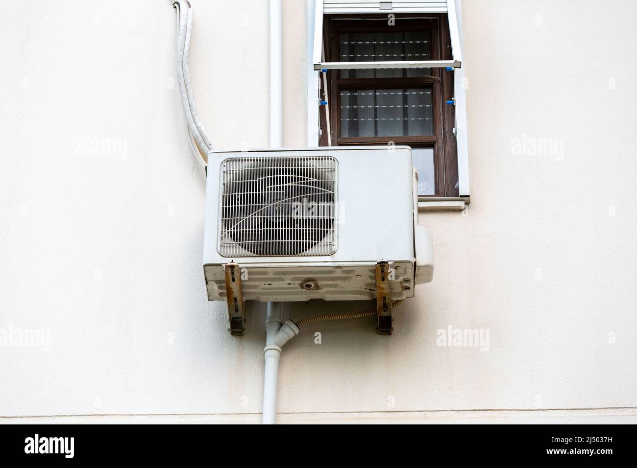 Split air conditioner outdoor unit hung outside the building Stock Photo