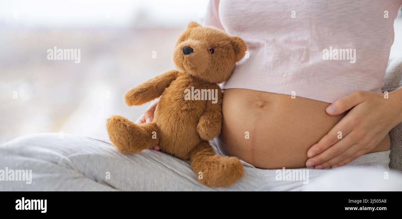Pregnant woman touching pregnancy stomach with baby to at home. Natural heath, skincare stretch marks, healthy foetus banner panoramic Stock Photo