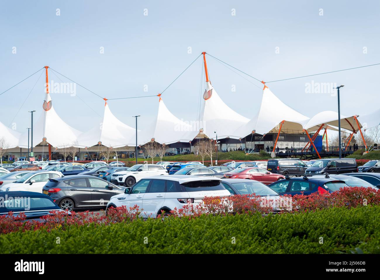 View across the full carpark of the large white tents of Ashford Outlet Center, Kent, England.  Stock Photo