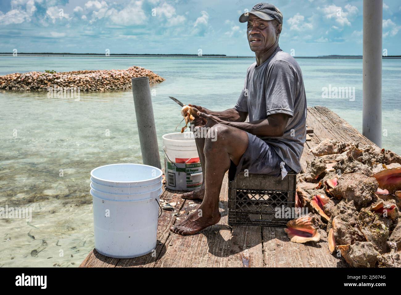 A fisherman dresses conch at native Bahamian seafood restaurant on the