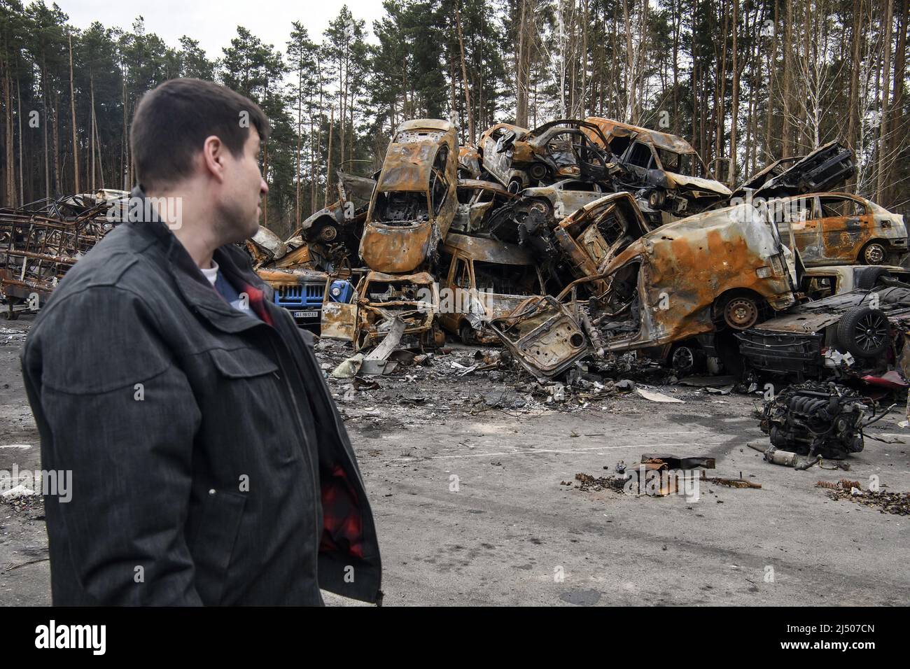 A Ukrainian man looks at cars destroyed during the ongoing Russian invasion of Ukraine, at a junkyard in Irpin, Ukraine on Monday, April 18 2022. Russian troops entered Ukrainian territory resulting in fighting and destruction in the country, a huge flow of refugees, and multiple sanctions against Russia Photo by Vladyslav Musiienko/UPI Credit: UPI/Alamy Live News Stock Photo
