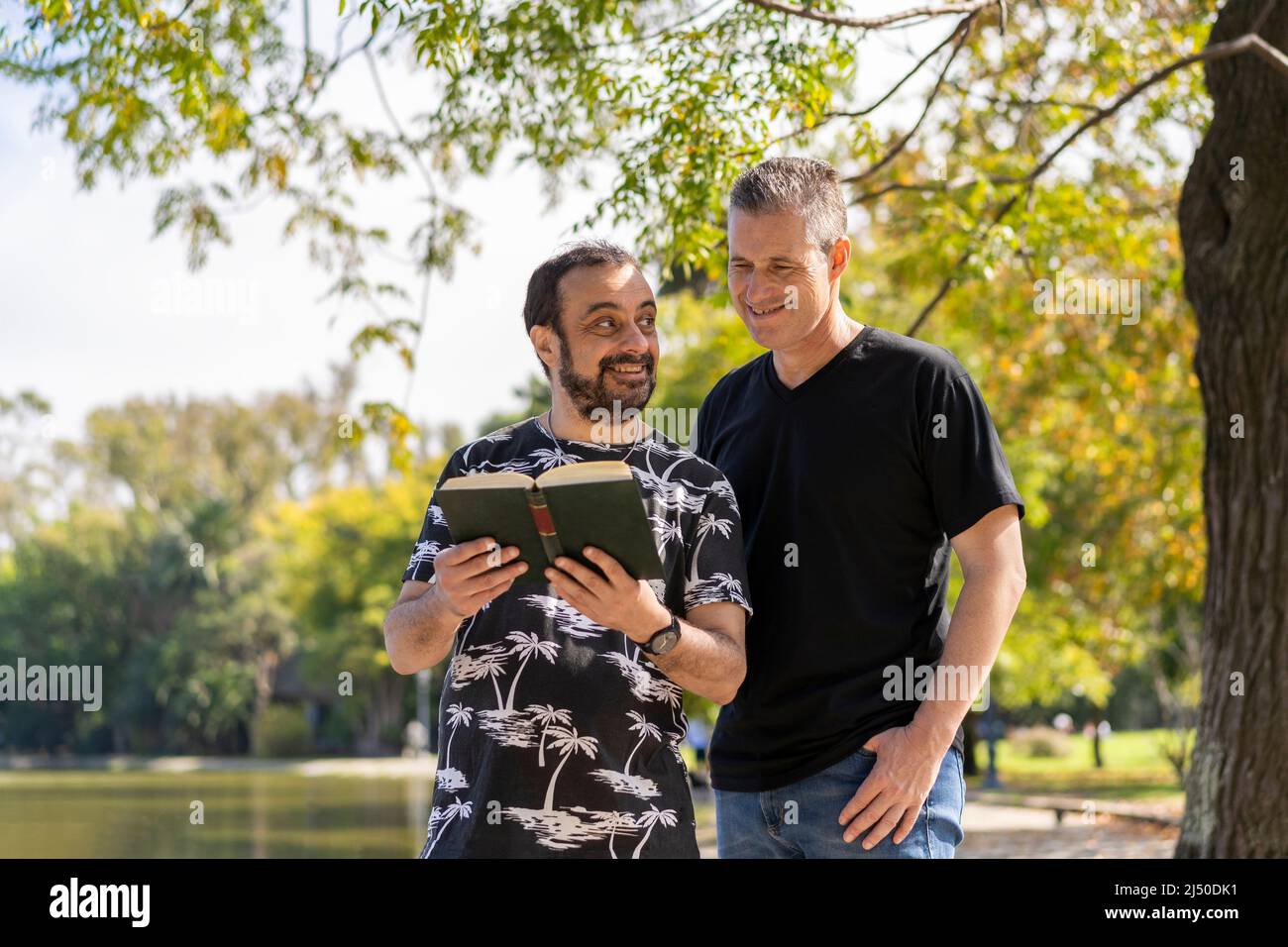 Couple of mature men reading in a lake, with a happy and relaxed attitude Stock Photo