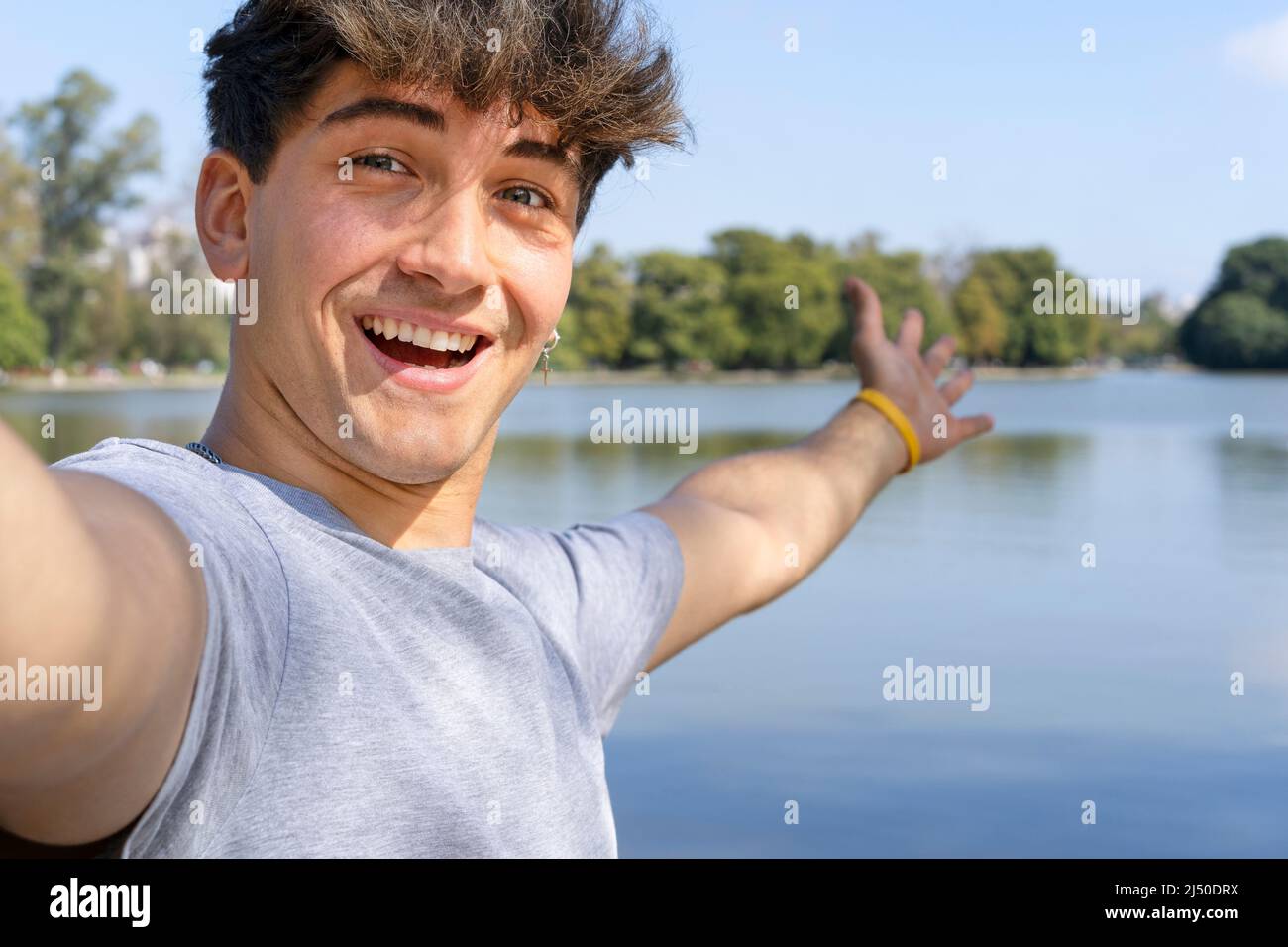 Active handsome young Caucasian man taking selfie showing around at a lake. Outdoor adventure concept. Stock Photo