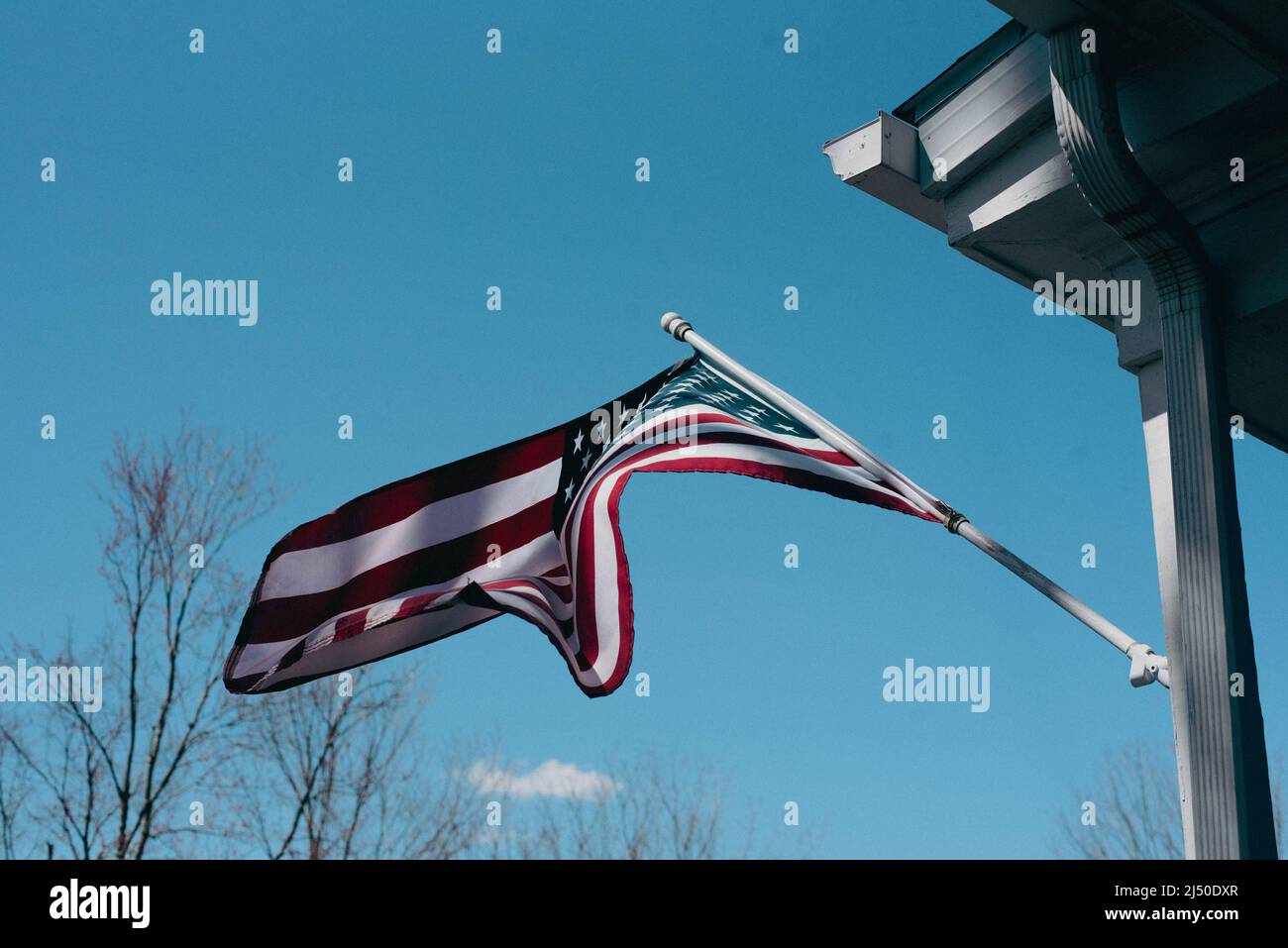 American flag flying outside a home Stock Photo