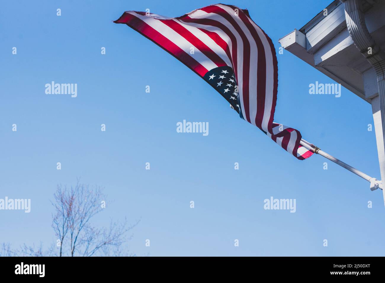 American flag flying outside a home Stock Photo