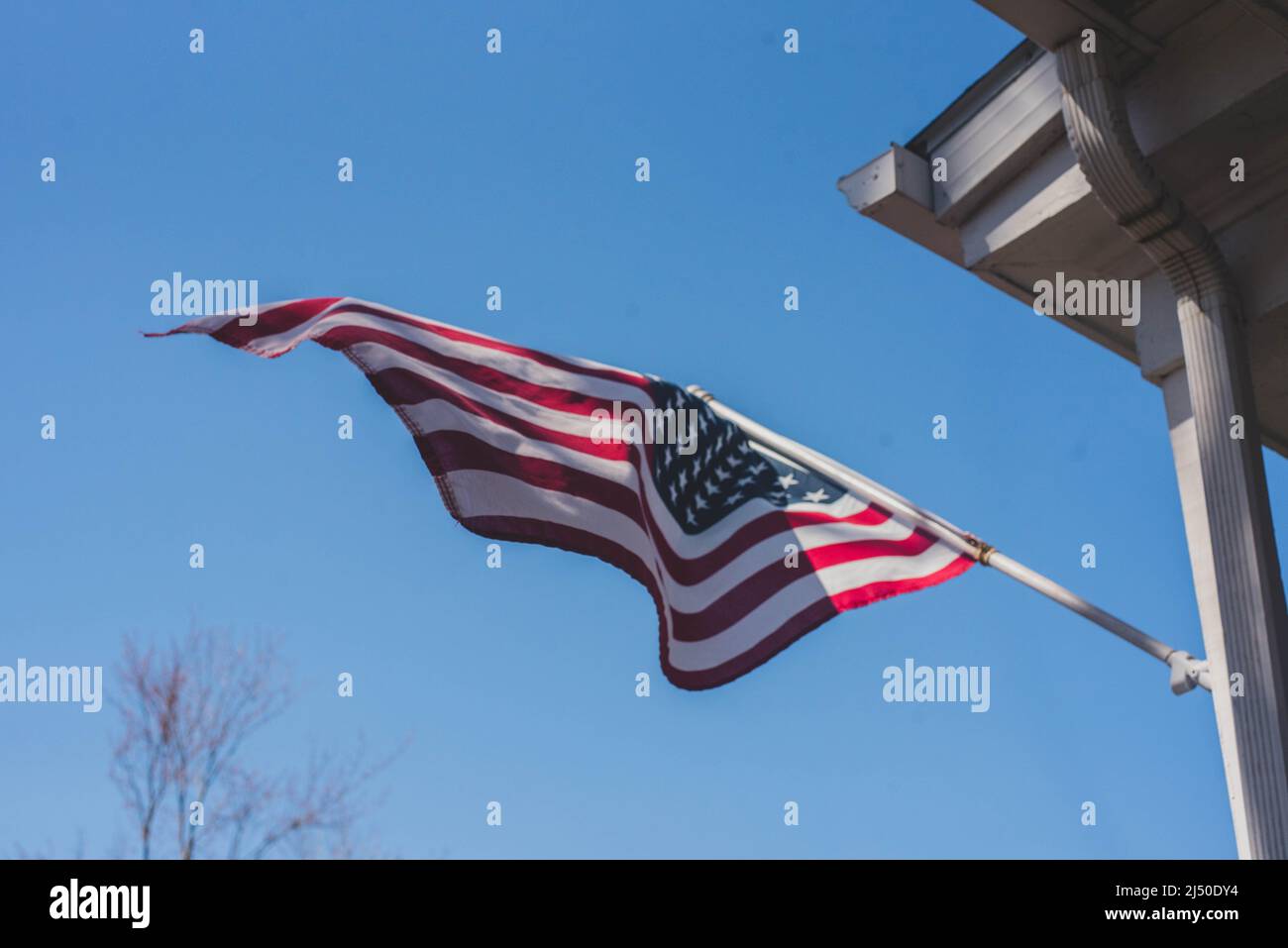 American flag flying outside a home - Stock Image