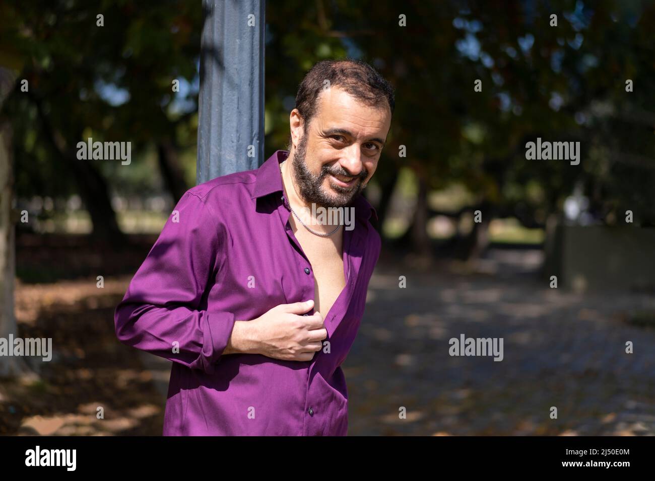 Portrait of a mature bearded man leaning on a lamp post looking at the camera Stock Photo