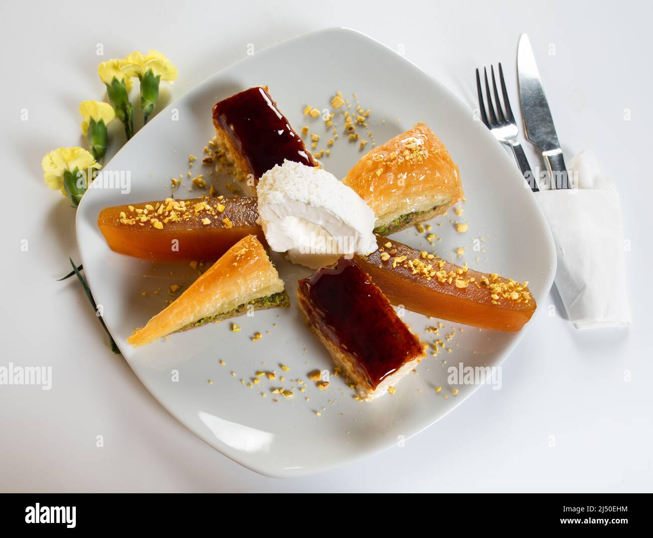 Mixed dessert plate in Turkish cuisine. Slices of Baklava, Trilece and Pumpkin Dessert are in a plate. Stock Photo