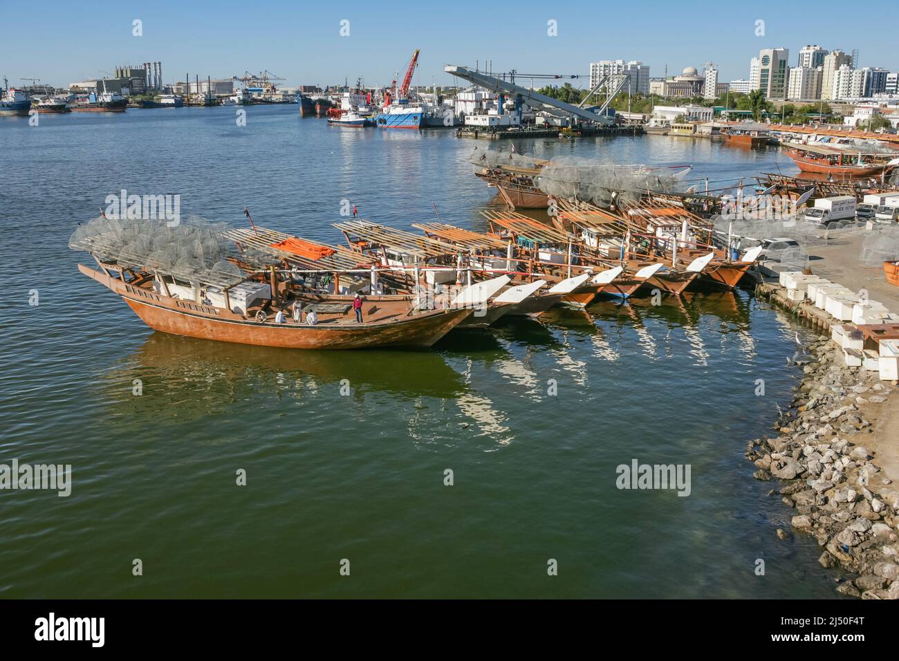 Traditional fishing dhows laden with gargours, or fish traps, lined up near Sharjah Bridge in Sharjah in the United Arab Emirates. Stock Photo