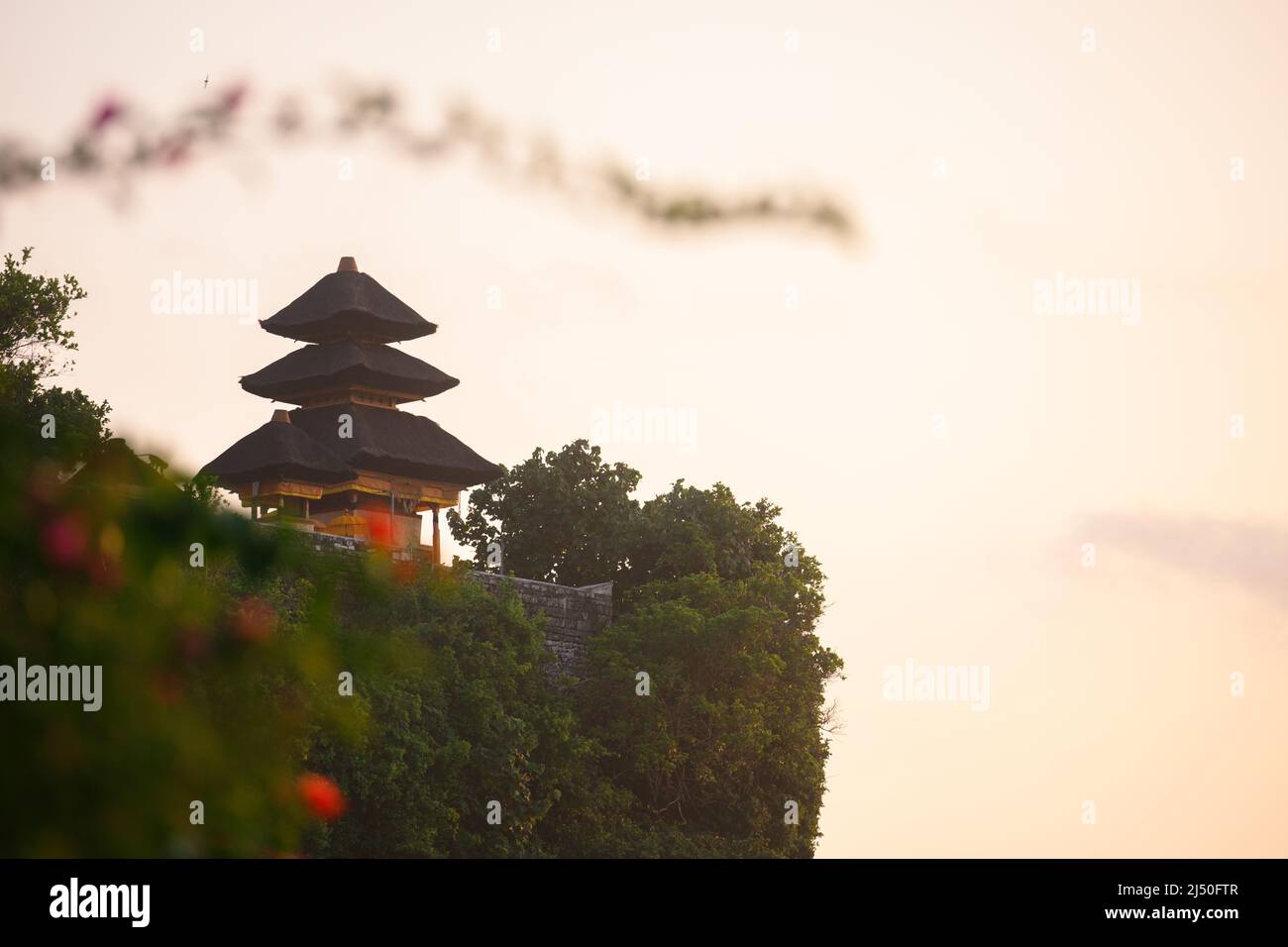 Balinese Temple on the Cliff against the warm sky Stock Photo