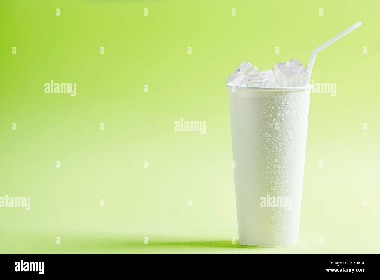 White plastic cup with ice cubes on a colored background Stock Photo