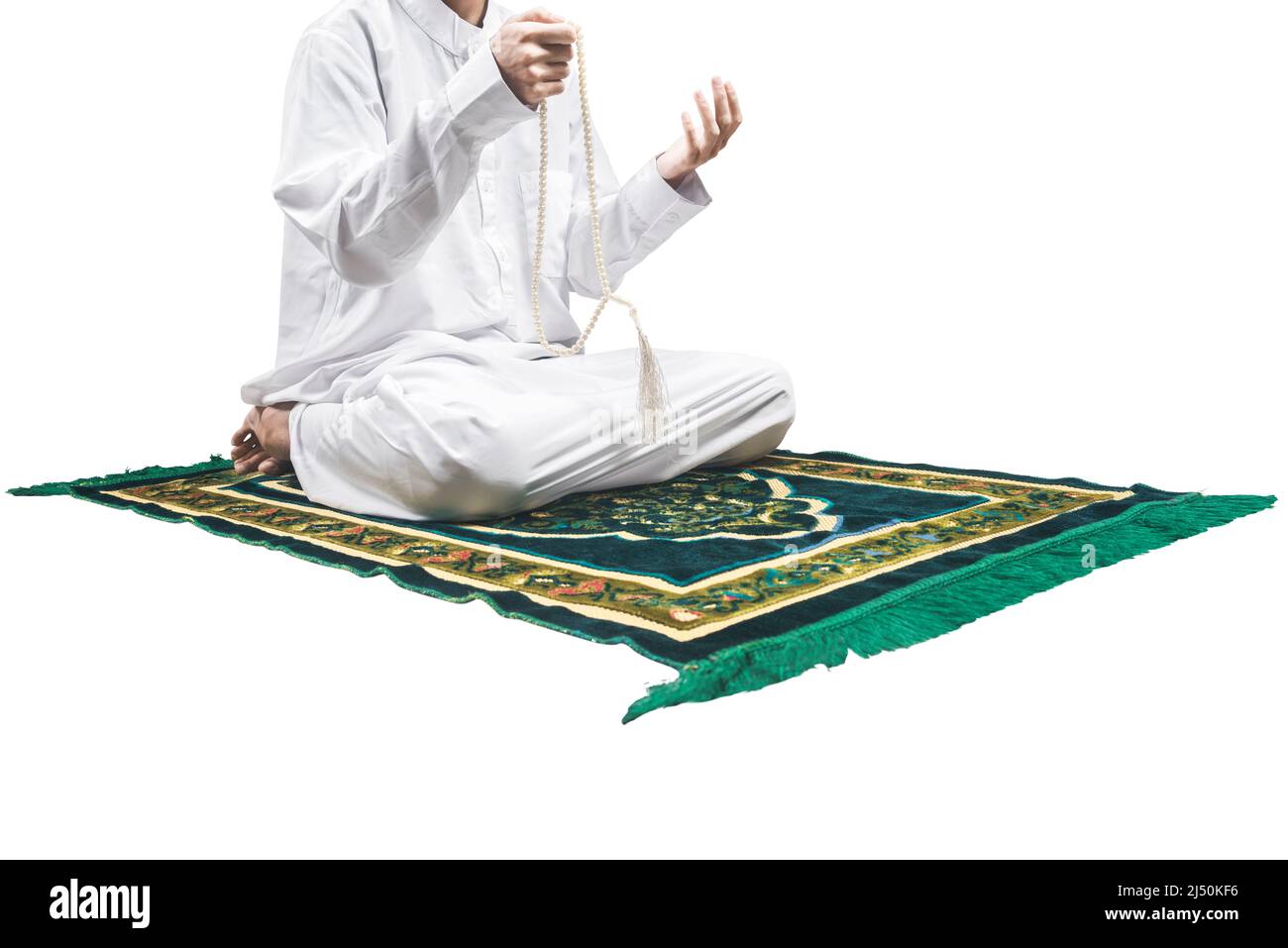 Muslim man praying with prayer beads on his hands while sitting on the