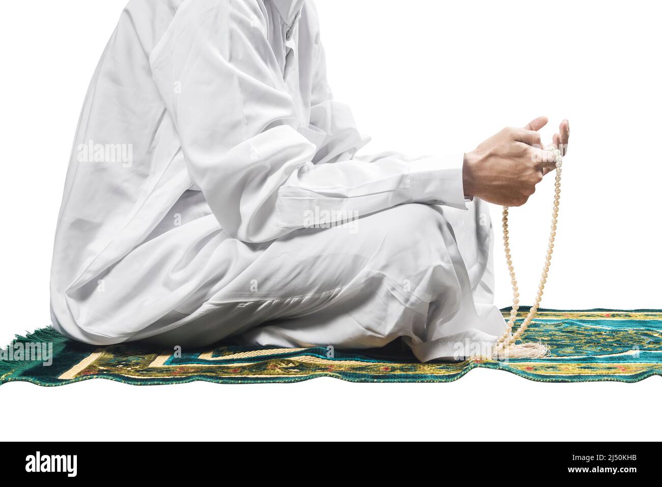 Muslim man praying with prayer beads on his hands while sitting on the
