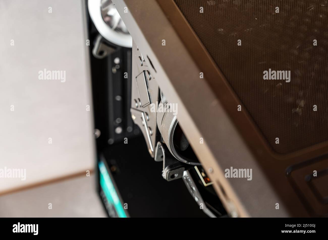 Fragment of a personal computer system unit. Black metal case with a dammed side cover. Modern digital devices. Stock Photo