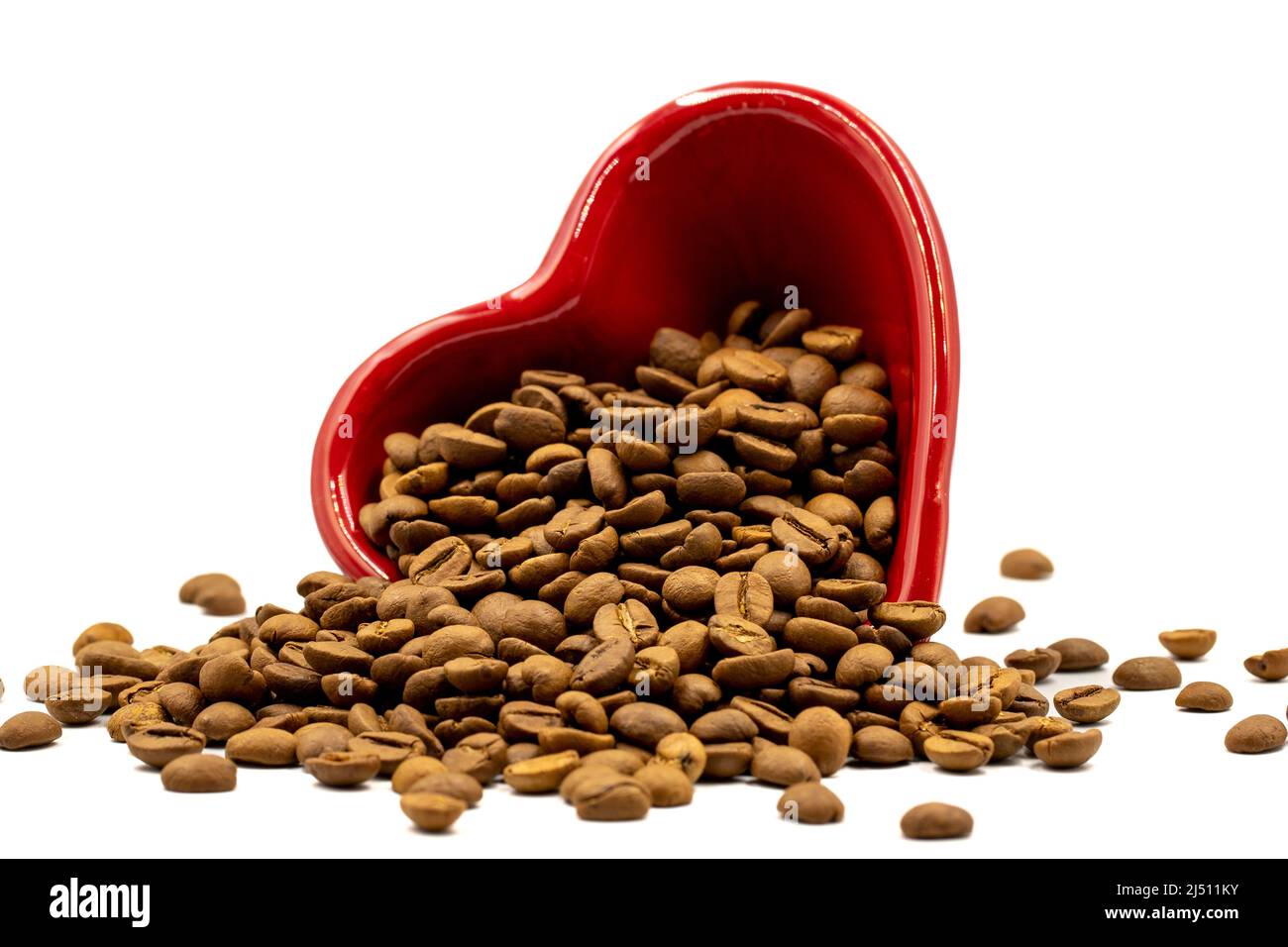 Coffee beans isolated on a white background. Full of coffee beans in a heart shaped plate. Close-up. Stock Photo