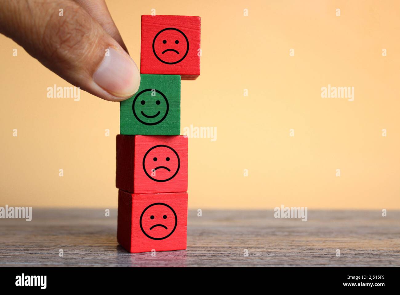 Hand pick happy face icon over sad face icon. Happiness in sadness, mixed feeling, ambivalent