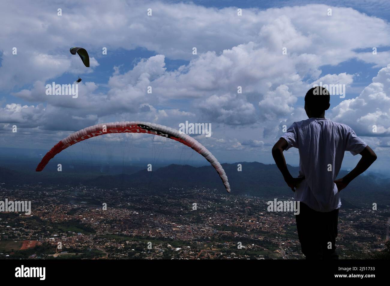 A festival assistant watches as paragliders fly with passengers during the  annual Easter paragliding festival in Kwahu-Atibie, Ghana April 15, 2022.  Picture taken April 15, 2022. REUTERS/Francis Kokoroko Stock Photo - Alamy