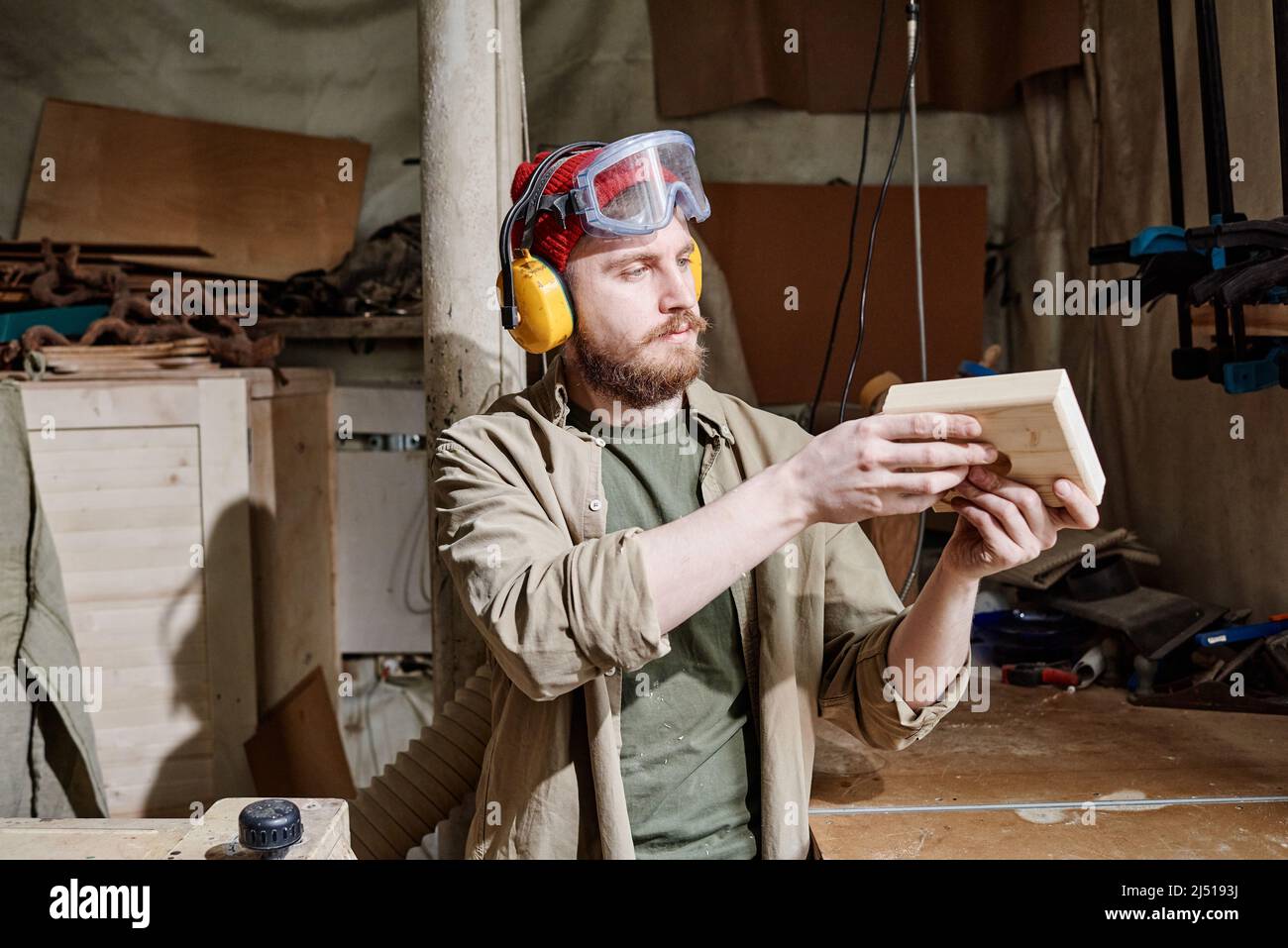 Professional carpenter wearing noisecancelling headphones and safety