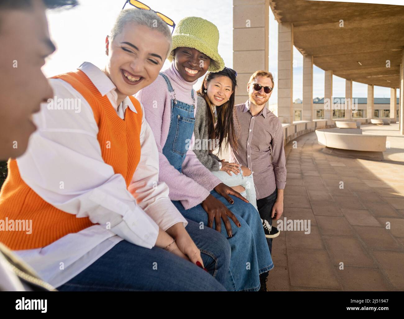 Group of multiracial friends having fun together while hanging out outdoors. Stock Photo