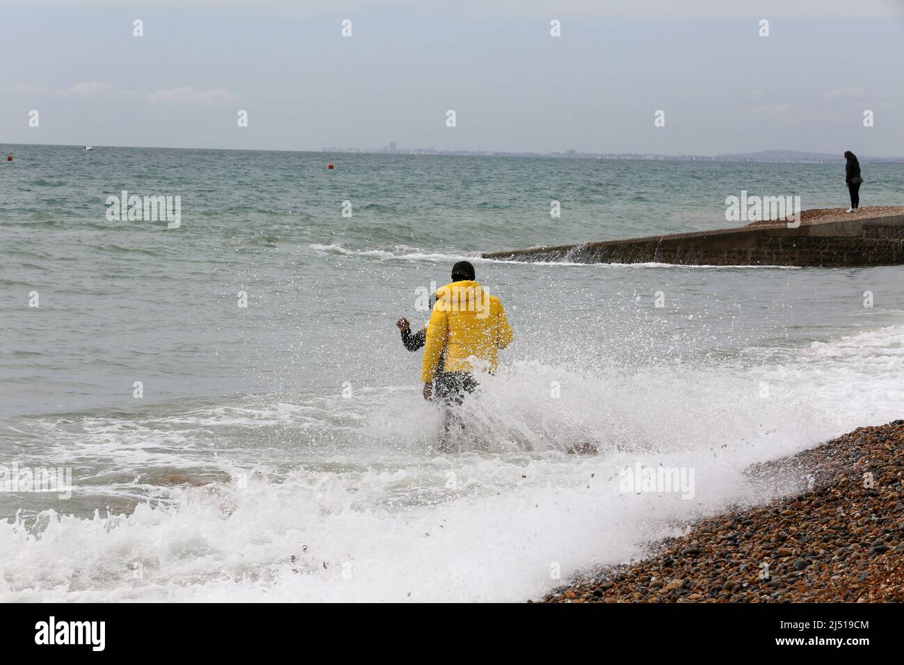 Brighton. UK 18 Apr 2022 - People enjoy the tidal wave as it come in on Easter Monday on the Brighton seafront as the mini-heatwave is set to end with light showers and temperatures of around 13 degrees Celsius. Credit Dinendra Haria /Alamy Live News Stock Photo