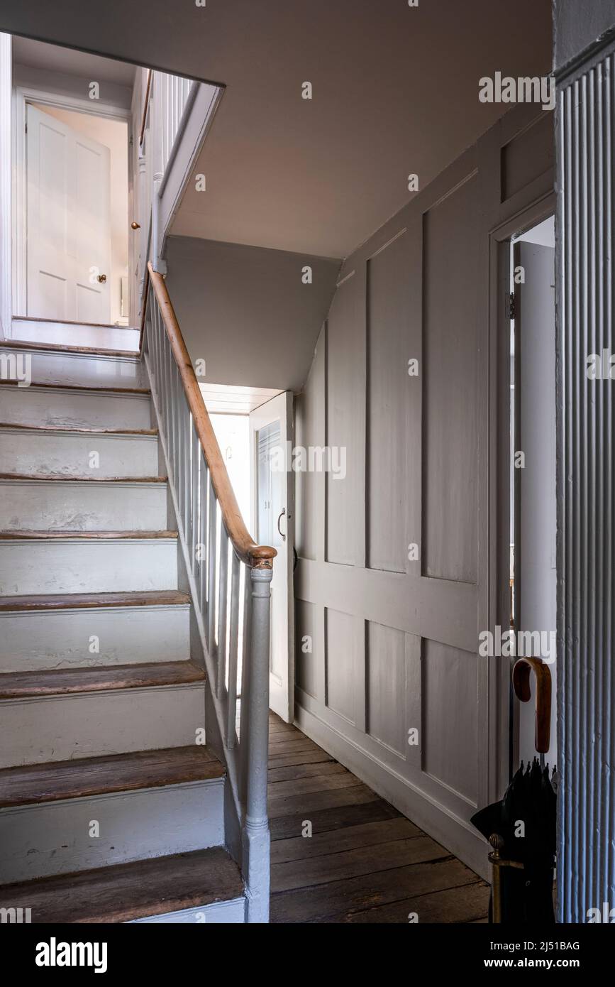 Wooden staircase and panelled walls with original Baltic pine floorboards in Grade II listed 1820s London cottage, UK Stock Photo