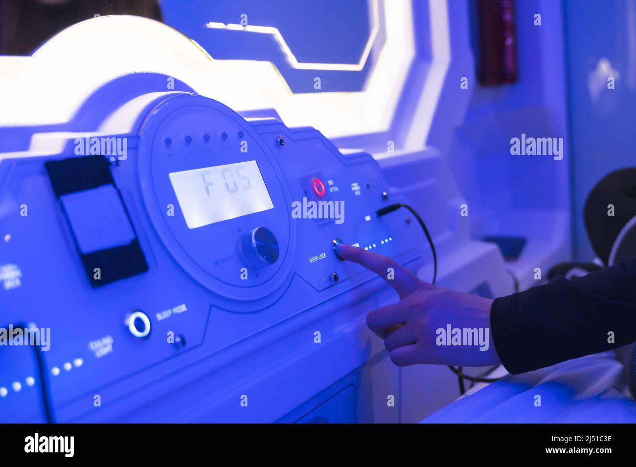 woman charging her device in bedroom capsule. Stock Photo