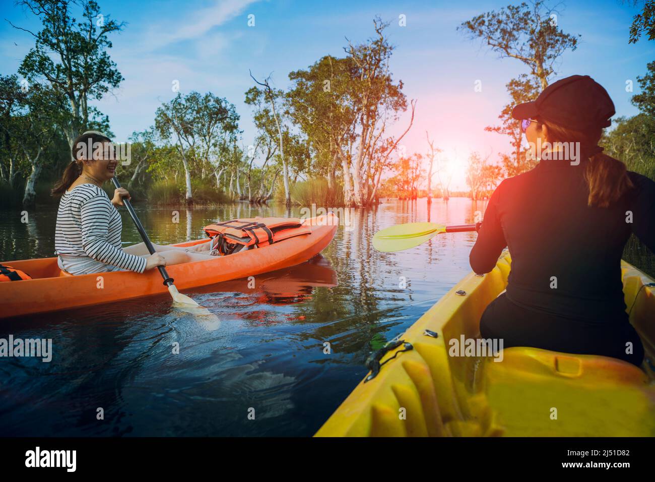 two asian woman sailing sea kayak in mangrove lagoon Stock Photo