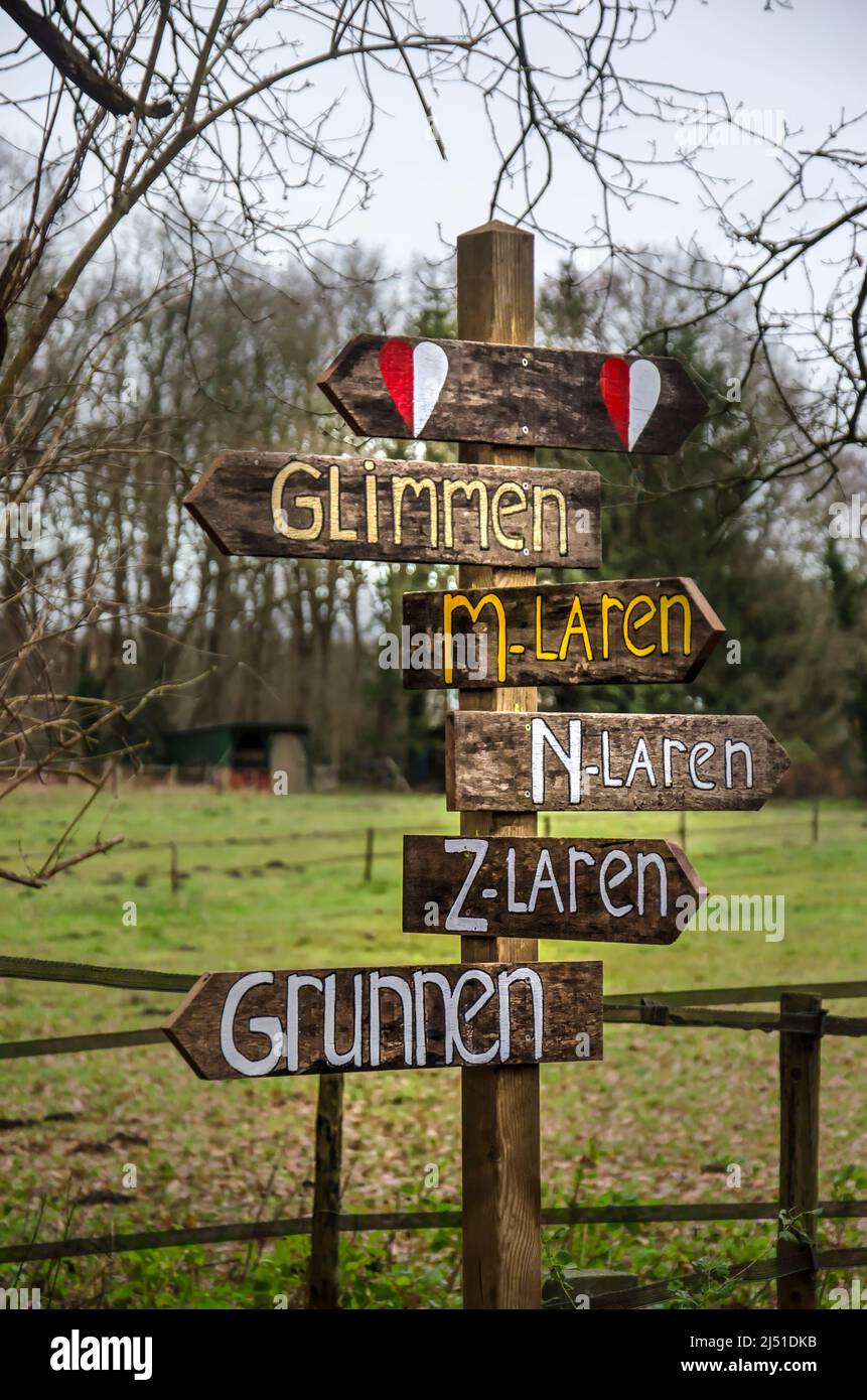 Zuidlaren,The Netherlands, December 8, 2019: handmade wooden sign indicating place names along the Pieterpad long distance trail Stock Photo