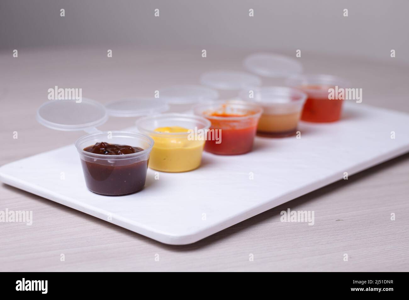 saucers with different types of sauce on a white background Stock Photo
