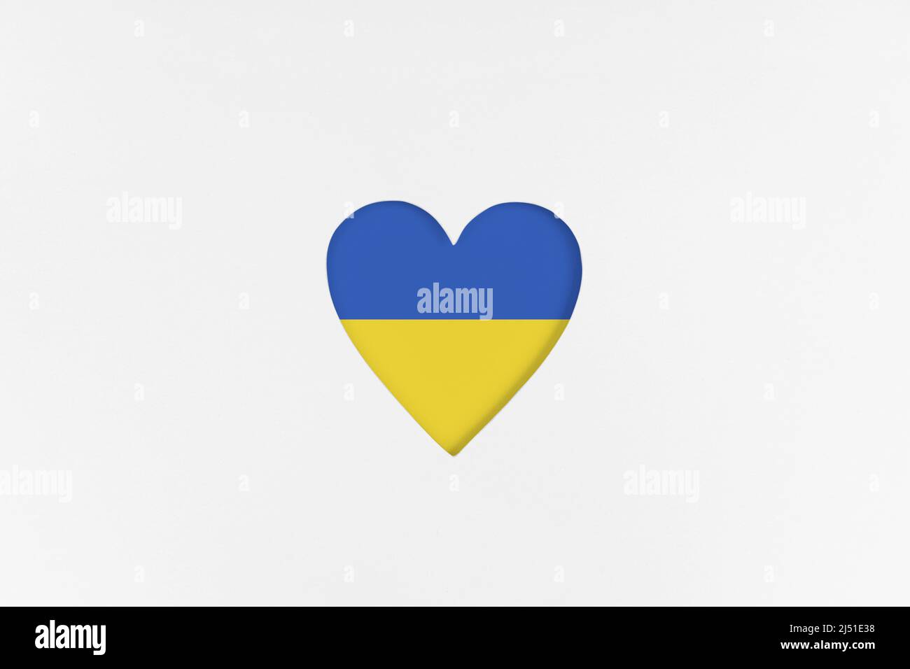 Ukraine flag on Heart shape isolated on white cardboard background. Printed cardboard with die-cut heart shape. Top view Stock Photo