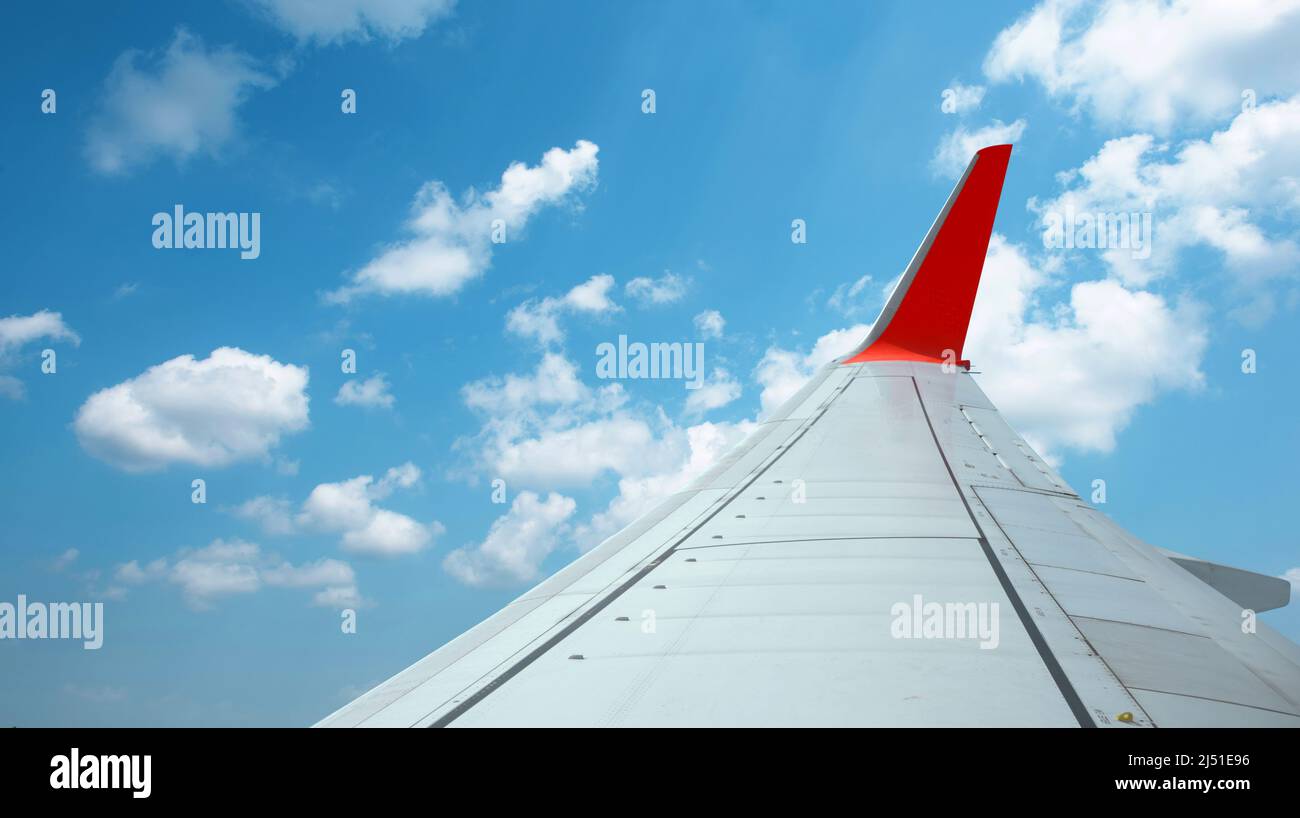 The wings of an airplane flying above the clouds. Stock Photo