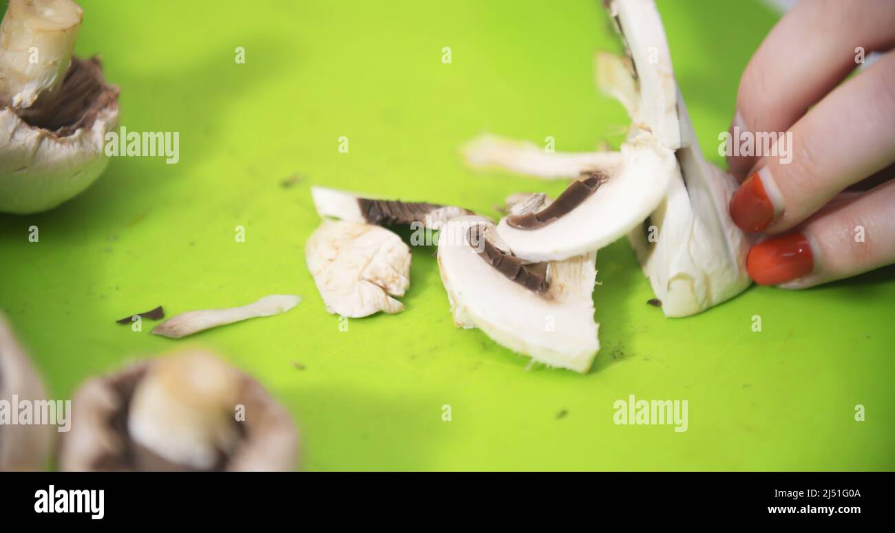 Housewife slicing mushrooms in the kitchen for cooking Stock Photo Alamy