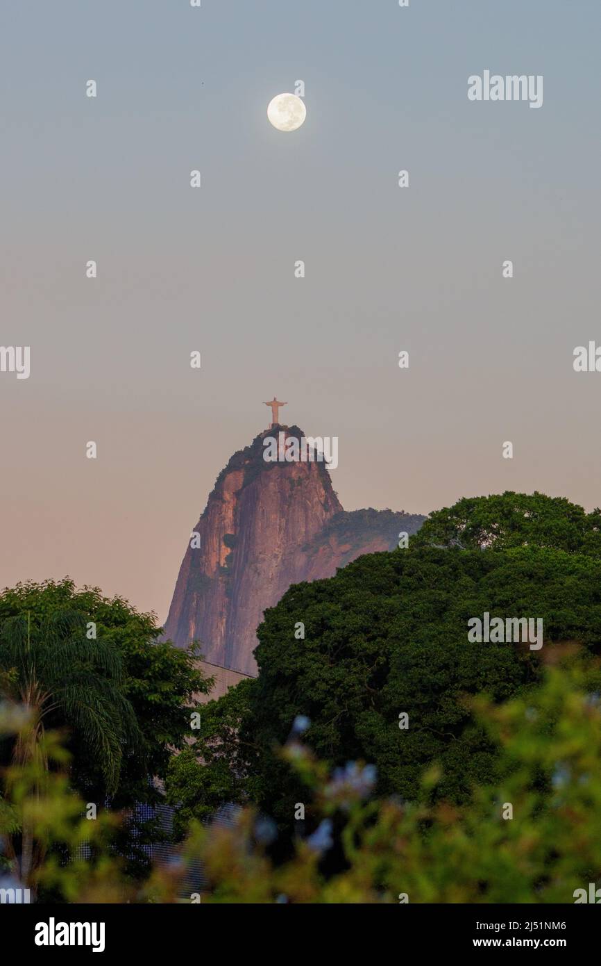 Christ the Redeemer and the Moon in Rio de Janeiro, Brazil - March 19, 2022: Moon setting near the statue of Christ the Redeemer in Rio de Janeiro. Stock Photo