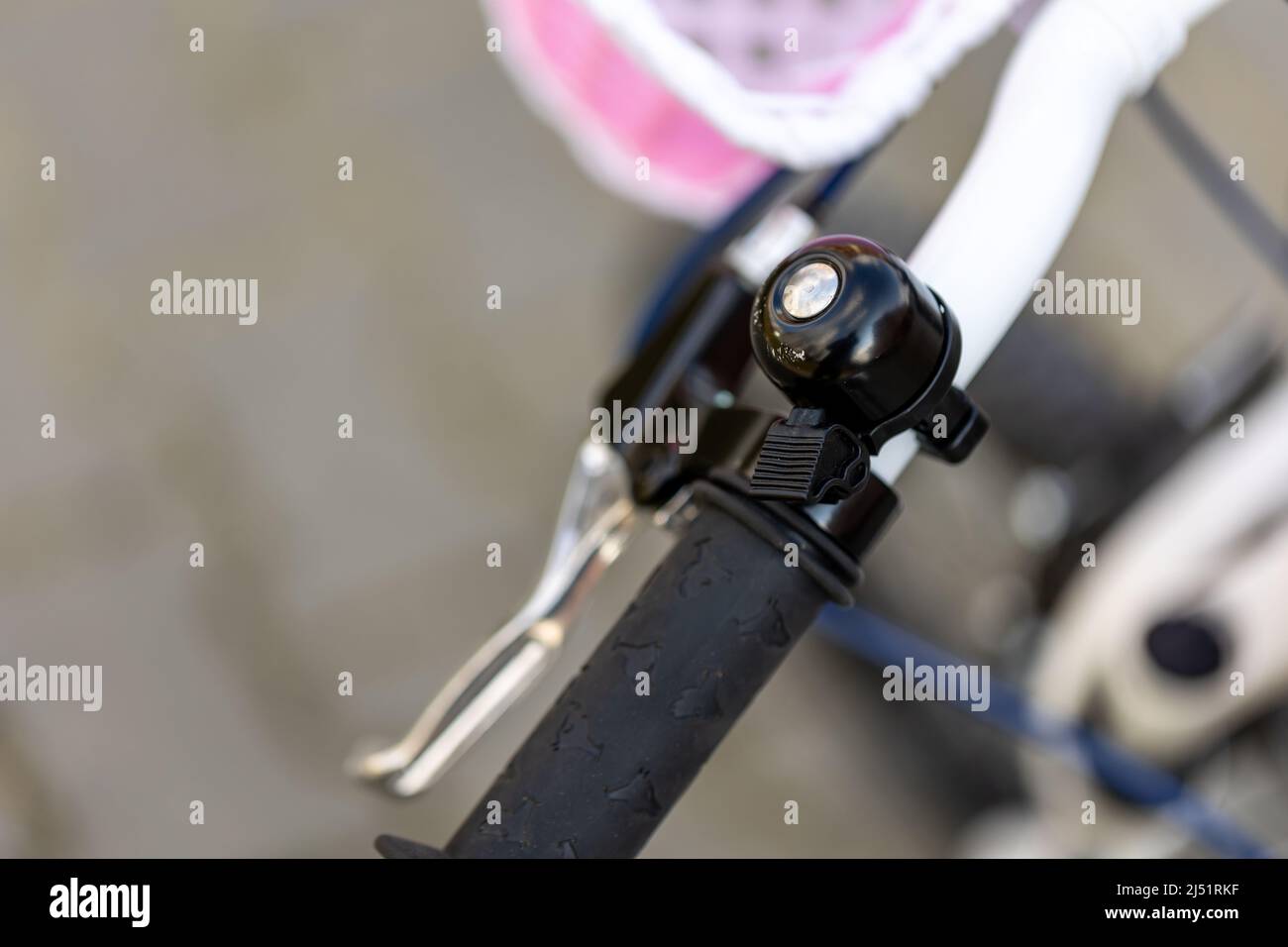 White children's bike, close-up of the bell attached to the handlebar. Blurred background, photo taken in natural, soft light Stock Photo