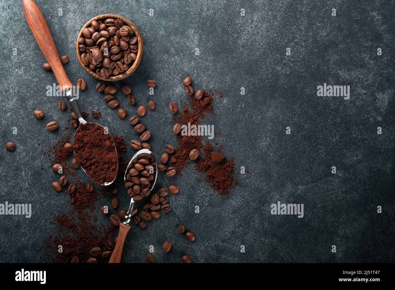 Coffee beans background. Roasted coffee concept with differents types of beans and cinnamon sticks on dark black stone background. Top view. Coffee co Stock Photo