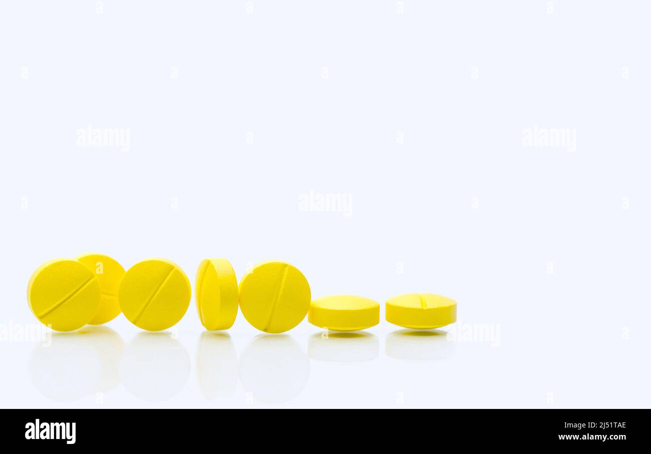 Yellow tablets pills on white background. Prescription drugs. Pharmaceutical industry. Healthcare and medicine. Pharmacy drugstore web banner. Tablets Stock Photo