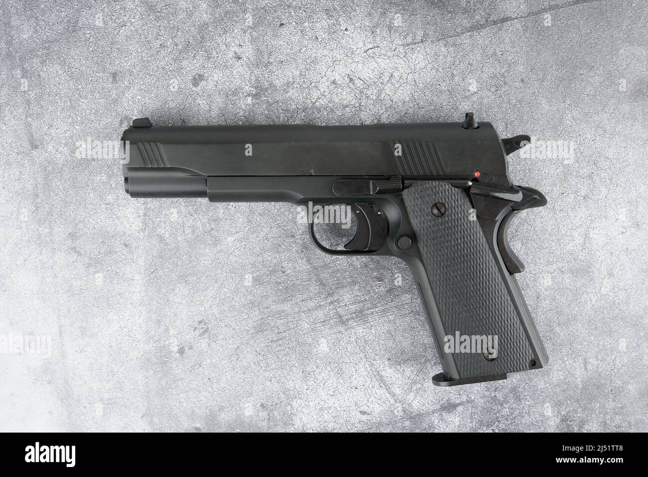 Black semi-automatic pistol on concrete backdrop Stock Photo