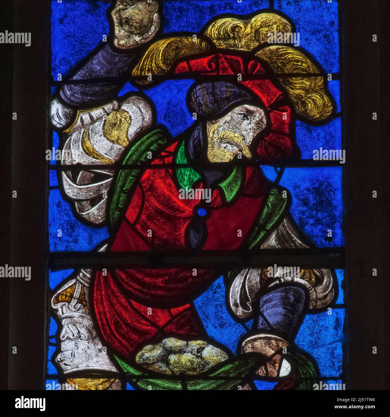 An executioner in colourful 1500s costume hurls stones at Christianity's first martyr, Saint Stephen, in a vivid square detail of early 1500s stained glass in the Église Saint-Rémi at Ceffonds, in the Champagne region of northeast France.  The colours are typical of Renaissance glass made in the workshops at Troyes, the historic regional capital. Stock Photo