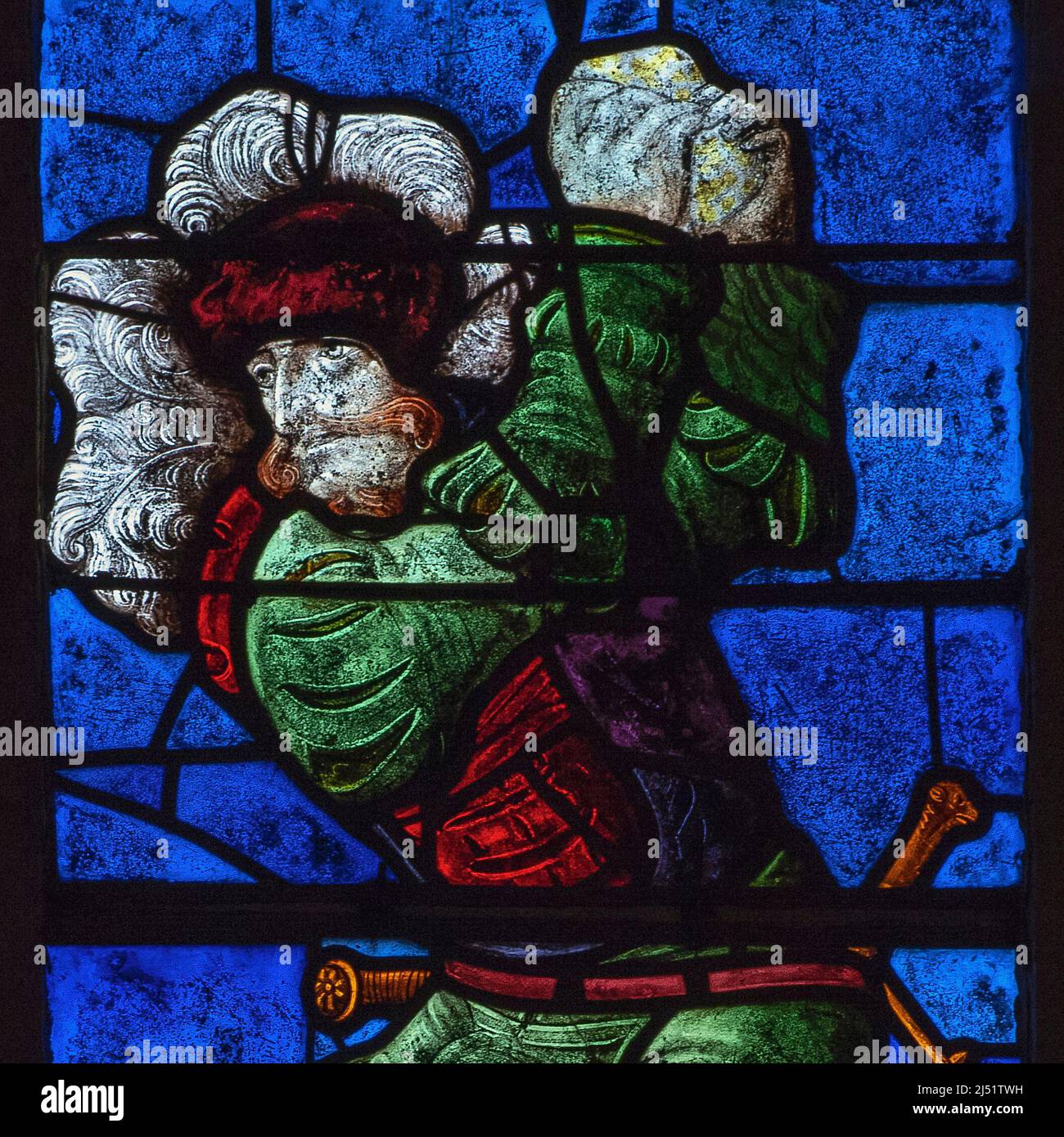 An executioner in colourful Renaissance costume hurls rocks at the first  Christian martyr, Saint Stephen, in this square format detail of vivid  early 1500s stained glass in the Église Saint-Rémi at Ceffonds,