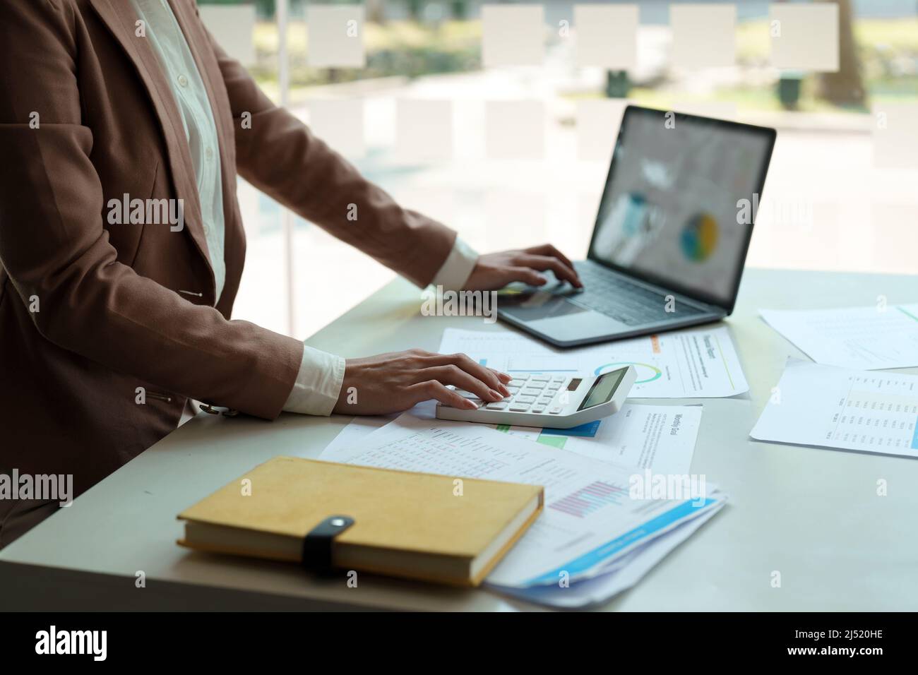 Close up a accountant working about financial with calculator and