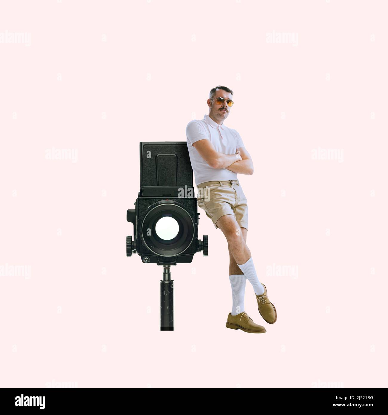 Contemporary art collage. Brutal stylish man leaning on retro camera device  isolated over light peach background Stock Photo - Alamy