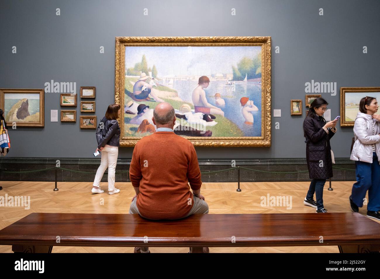 A man looking at the Bathers at Asnières painting in The National Gallery in London, England. Stock Photo
