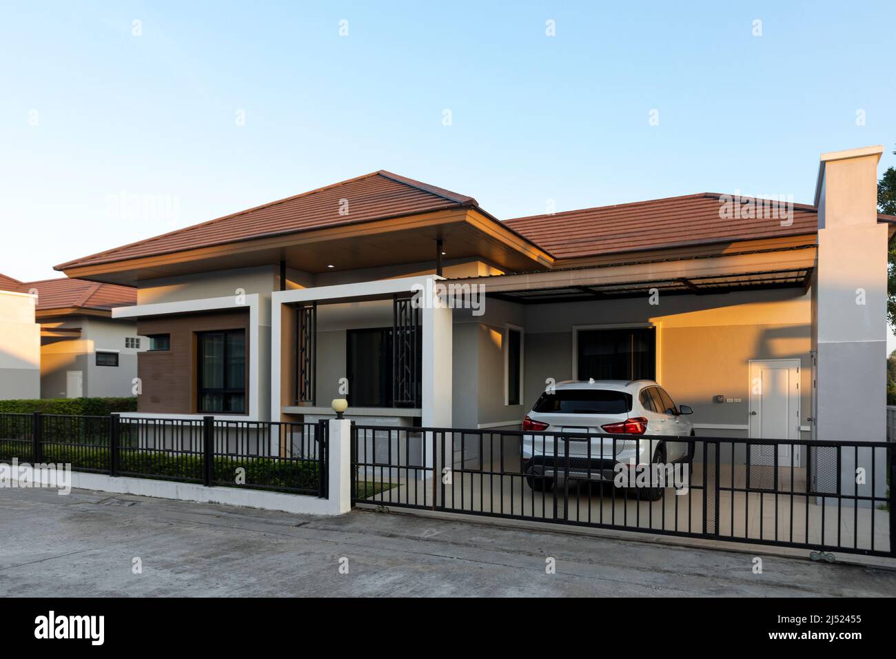 Outside view of the house with green fields against clear blue sky