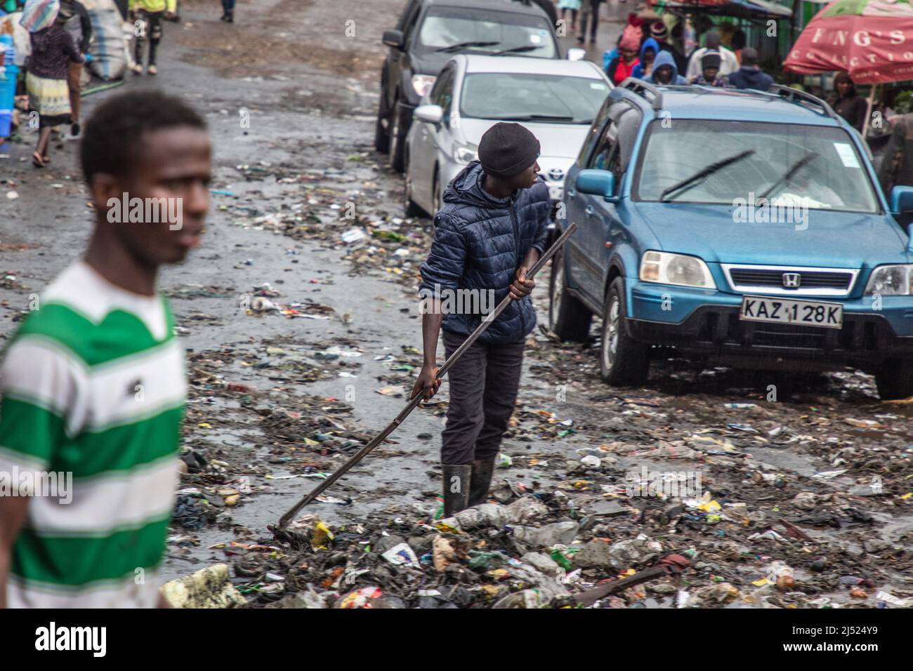A boy pushing rubbish on the road after heavy rains rains in Kibera on April 18, 2022.  The rainy season brings relife to the drouhgt-hit areas, but for the residents of Kibera the rains can be a sign of the worst to come ( Photo by Samson Otieno/Sipa USA) Stock Photo