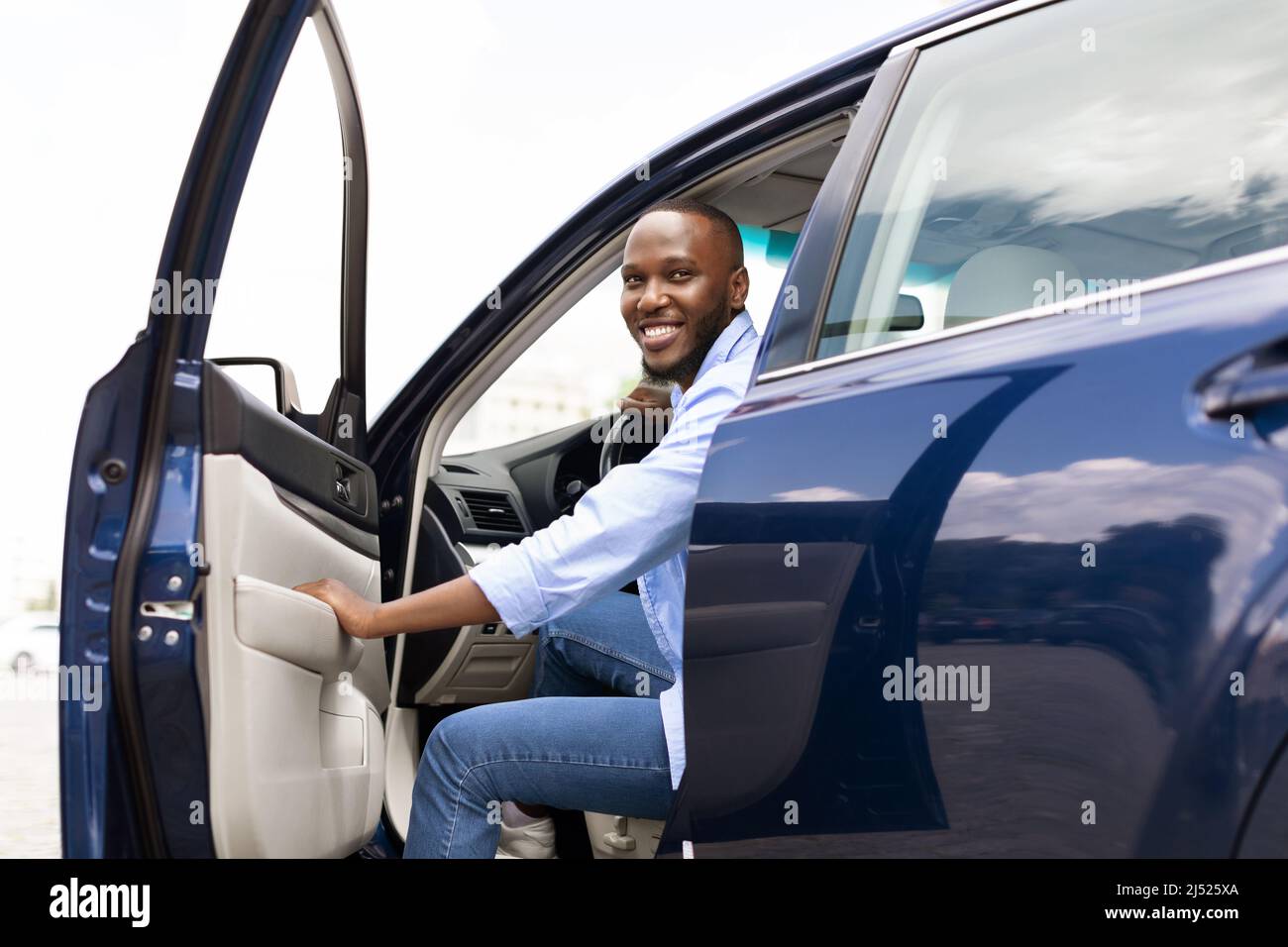 Smiling black man driving new car in the city Stock Photo Alamy