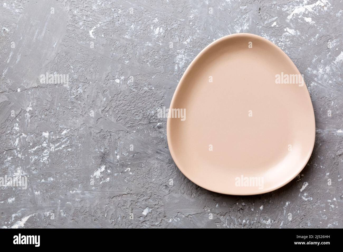 Top view of empty pink plate on cement background. Empty space for your ...